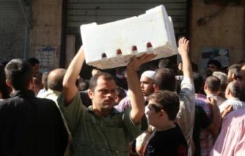 أحد سكان حلب يحمل صندوق معونات غذائية (رويترز)