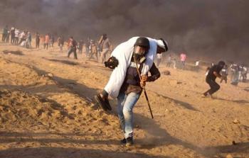الصحفي حاتم عُمر أثناء إنقاذه لمُسن فلسطيني شرق خان يونس