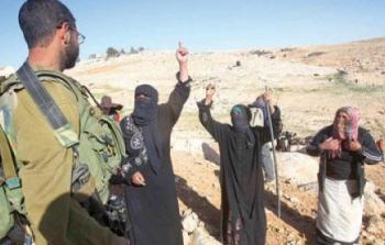 جندي اسرائيلي يقف أمام بدو فلسطينيون