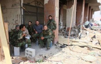 جنود سوريون يجتمعون في بلدة درايا التي أصابها دمار واسع
