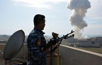 جندي عراقي يراقب تصاعد الدخان من جراء غارة على أحد مواقع داعش في الموصل.