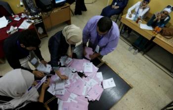 موظفون يحصون بطاقات الانتخاب في أحد مراكز الاقتراع في عمان