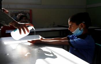 طالب فلسطيني يعقم يديه للحماية من فيروس كورونا