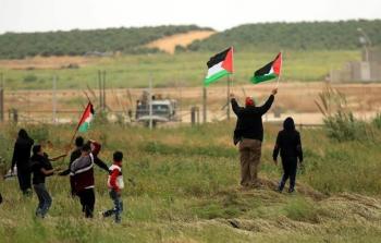 فلسطينون يرفعون العلم الفلسطيني على حدود غزة