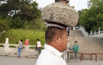 صينى يحمل حجراً بوزن 40 كيلوغراماً على رأسه 