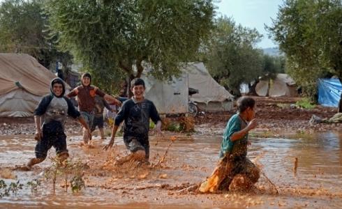 اطفال المخيمات يلهون بمياه الامطار