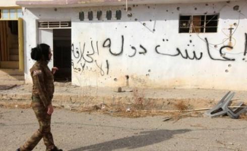 مقاتلة كردية في قرية محررة من داعش