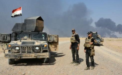 قوات عراقية خلال اشتباكات مع مسلحي تنظيم "الدولة الإسلامية" بضواحي القيارة.