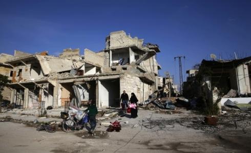 عائلة سورية على انقاض منزلها المدمر