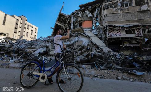 فلسطيني يمر بالقرب من قصف اسرائيلي استهدف أحد الأبراج في غزة