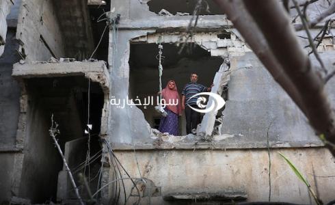 فلسطينيان يقفان على حافة منزل دمره الاحتلال في غزة