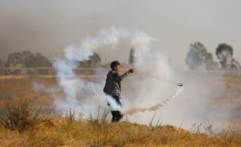 فلسطيني يرشق جيش الاحتلال بالغاز على حدود غزة