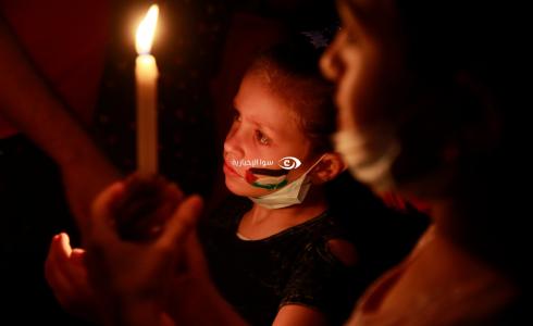 وقفة أطفال بالشموع على أنقاض منزل عائلتين في غزة