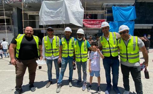 الطفل كريم مع العاملين في إعادة إعمار غزة