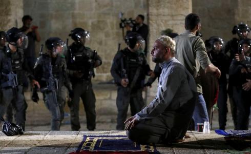 فلسطيني يصلى في المسجد الأقصى بالقدس قرب جنود اسرائيليين