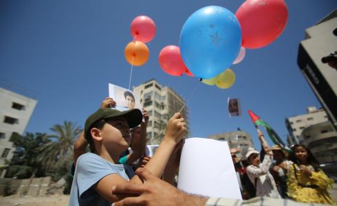 صورة لأحد الأطفال وهو يطلق بالونا يحمل رسائل انسانية الى العام