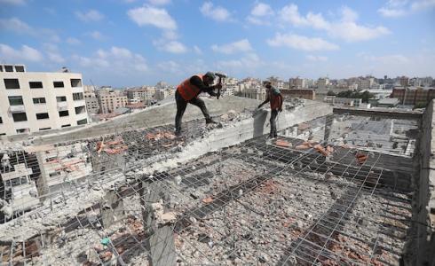 عمال فلسطينيون يعملون على إزالة ركام بناية مدمرة في غزة