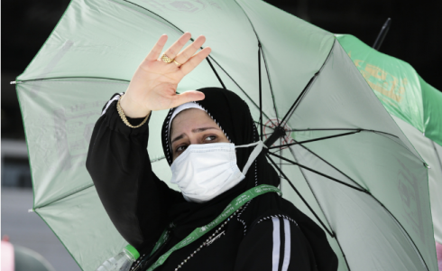صورة لحاجة وهي تلقي السلام على رجال الأمن في ساحة الحرم المكي اليوم أثناء أداء مناسك الحج