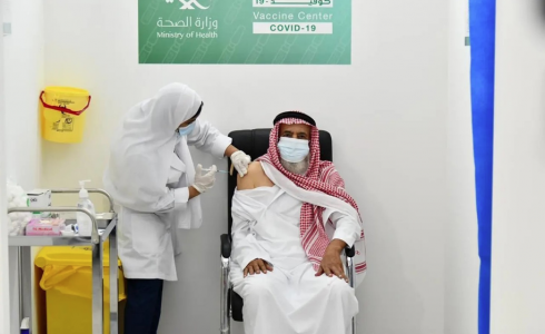 صورة أرشيفية لموظفة صحة سعودية تعطي مواطنا سعوديا جرعة مضادة من لقاح كورونا