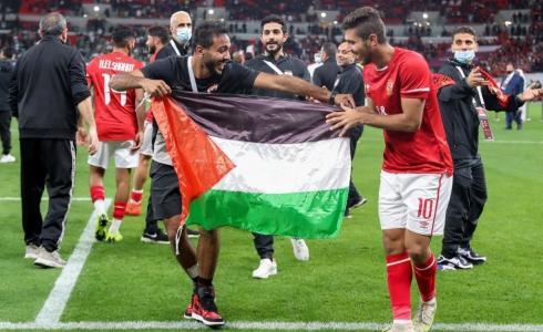 لاعبا الأهلي المصري محمود كهربا ومحمد شريف يرفعان علم فلسطين بعد التتويج بالسوبر الإفريقي