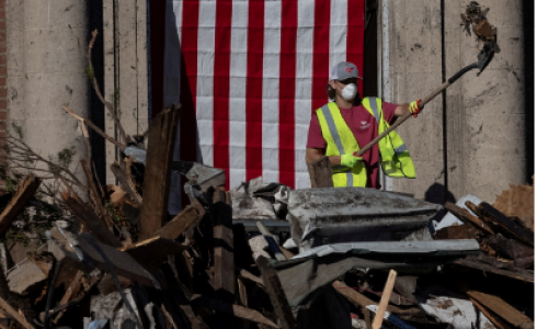 أحد المتطوعين يعمل على ازالة الركام من أحد المنازل التي تعرضت للاعصار في ولاية كنتاكي