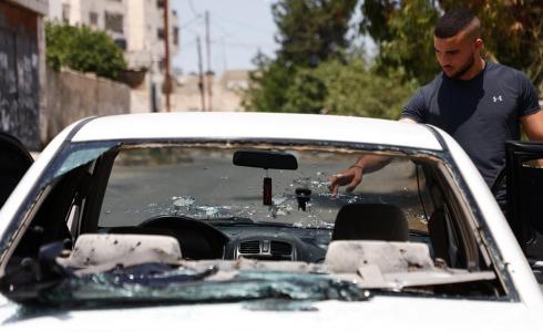 مواطنون يتفقدون المركبة التي اطلق الاحتلال نيرانه عليها في مدينة جنين