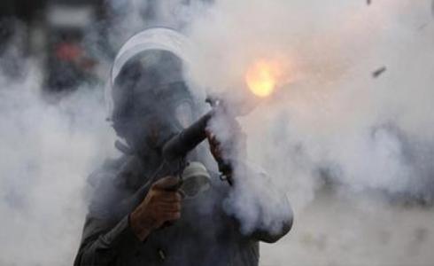 جندي إسرائيلي يطلق قنابل الغاز المسيل للدموع تجاه منازل الفلسطينيين - أرشيفية