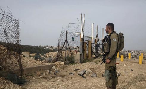 جندي إسرائيلي بالقرب من فتحة بالجدار الفاصل في الضفة