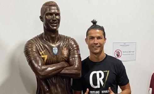 اللاعب كريستيانو رونالدو مع التمثال الخاص به