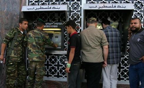 موظفون يسلمون الرواتب من بنك فلسطيني