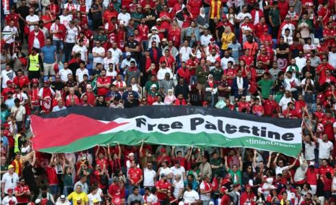 الجماهير ترفع علم فلسطين خلال مباراة تونس وأستراليا بكأس العالم في قطر (رويترز)