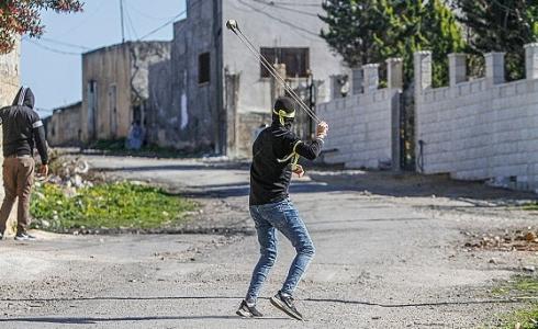 شاب فلسطيني يرمي الحجارة