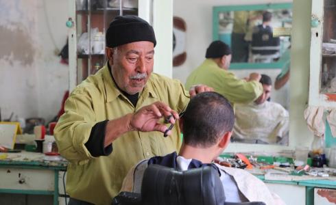 مُسن فلسطيني يعمل في مهنة الحلاقة
