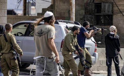 صورة أرشيفية/ مستوطنون يعربدون في بلدة حوارة بحماية قوات الاحتلال الإسرائيلي (تصوير: أ ف ب)