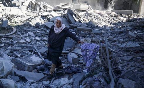 مسنة فلسطينية تقف على أنقاض منزل مدمر في قطاع غزة