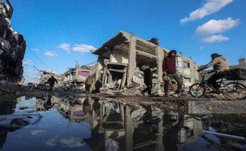 مواطنون يسيرون من أمام الدمار الذي خلّفه العدوان الإسرائيلي في حي الزيتون بمدينة غزة