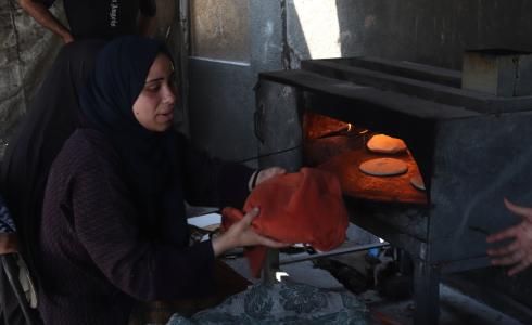 غزة - نازحات يخبزن تحت رماد الحرب
