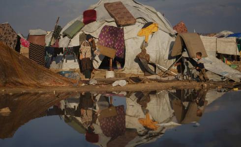 امرأة وطفل أمام خيمتهما في مخيم للنازحين على شاطئ مدينة غزة الثلاثاء (أ.ب)