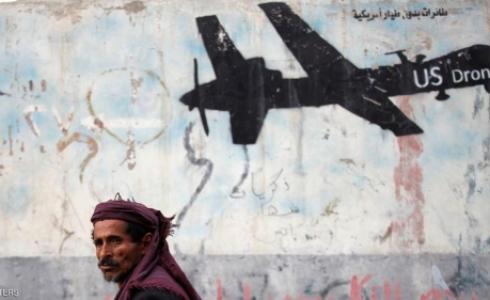 مواطن يمني يعبر جانب جدار برسومات غرافيتية لدرون