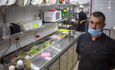 عمال يجهزون وجبات طعام في مطعم في تل أبيب أمس 