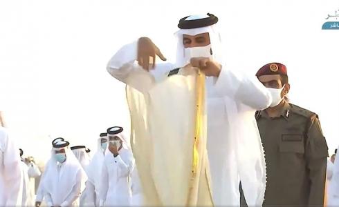 أمير قطر وهو يقلب ردائه