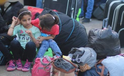 طفلتان ينتظرن السفر عبر معبر رفح