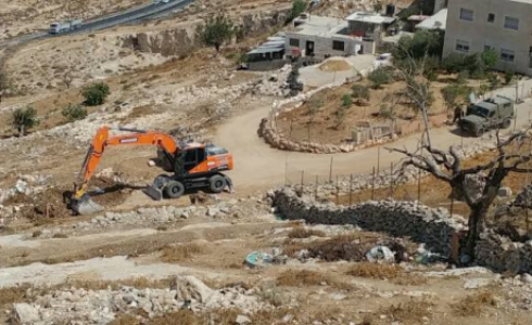 جرافة الاحتلال خلال شق الطريق 
