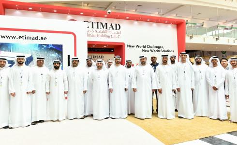 خالد آل علي يتوسط الموظفين في جناح مجموعة اعتماد القابضة في معرض آيدكس 2019 (1).jpg