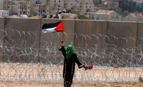 فلسطينية تحمل علم فلسطين