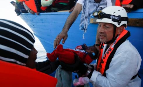 أحد المنقذين يحمل طفلا