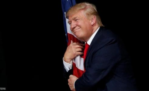 ترامب معانقا العلم الأميركي.