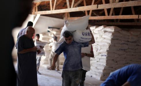 لاجئ فلسطيني يتسلم معونة غذائية من أحد مراكز الاونروا بغزة
