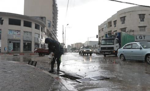 أحد طواقم بلدية غزة يقوم بتصريف مياه الأمطار 