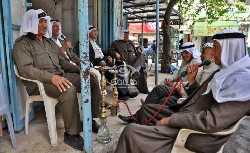 مسنون فلسطينيون يدخنون في أحد مقاهي